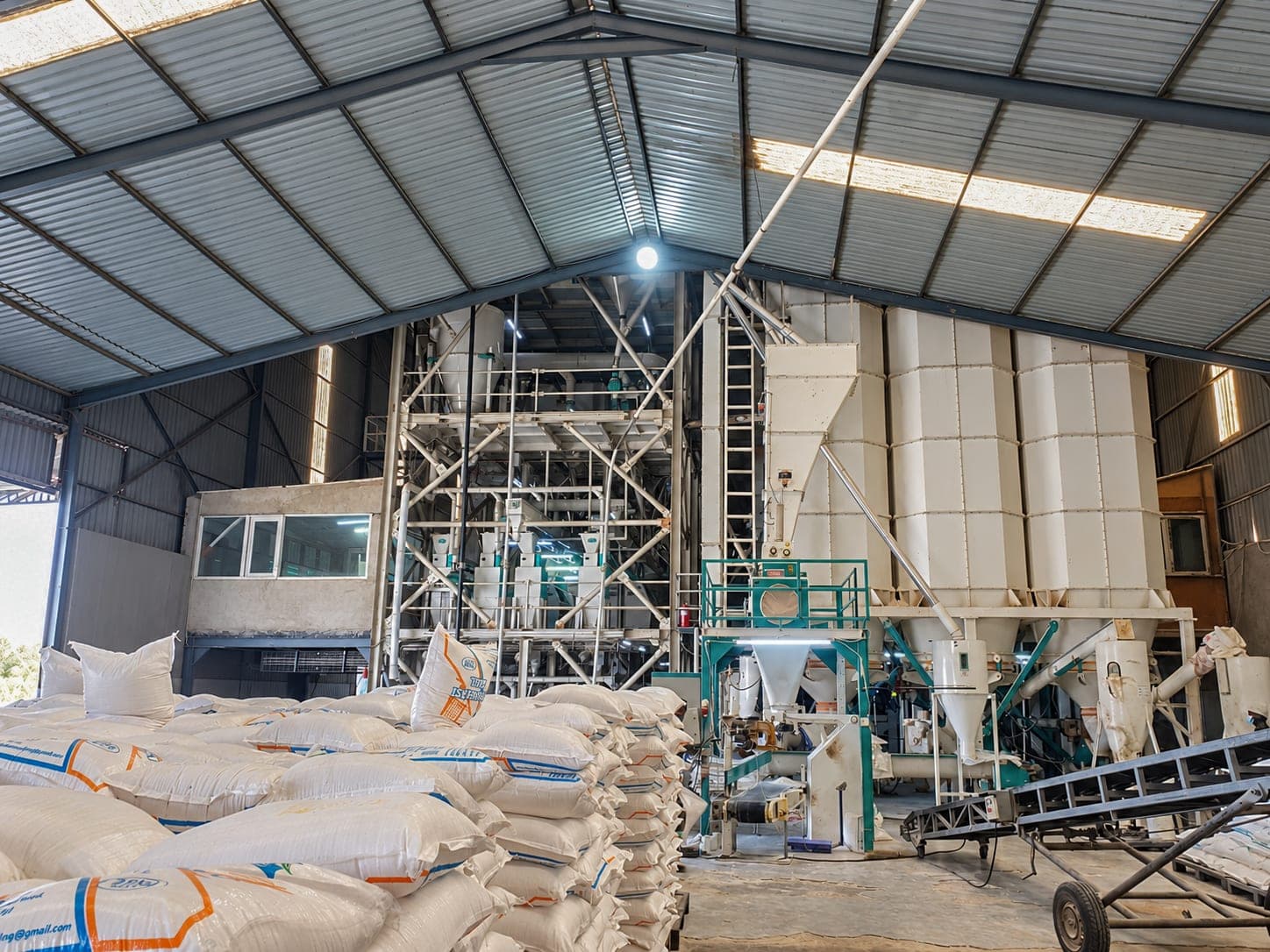 The Good Taste Milling floor, with pallets of bagged meal stacked beside the mill plant